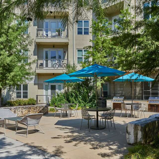 Community courtyard area with lounge seating and tables with umbrellas