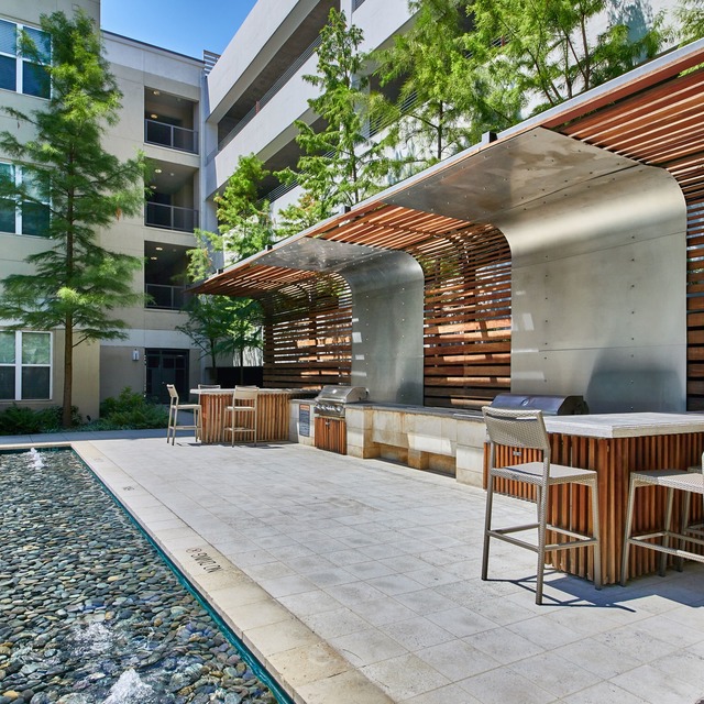 Poolside lounge area with BBQ grills and high-top seating areas