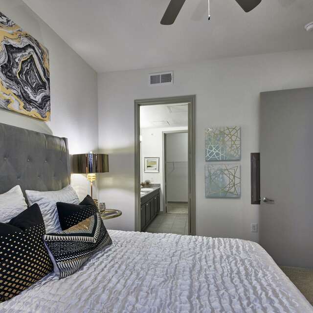 Bedroom en-suite with a large bed and artwork on the walls