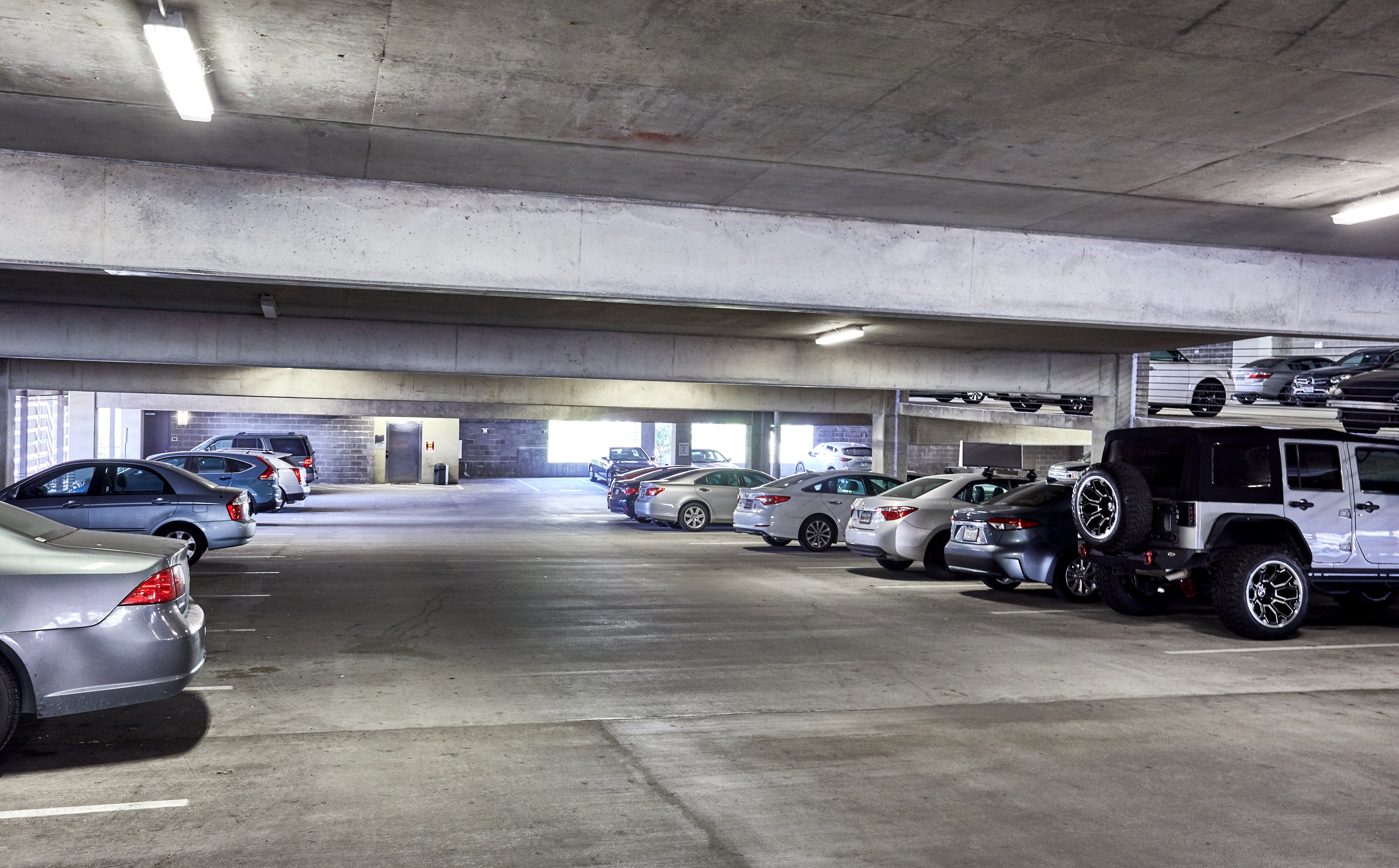 Multi-level parking garage with parked cars in it