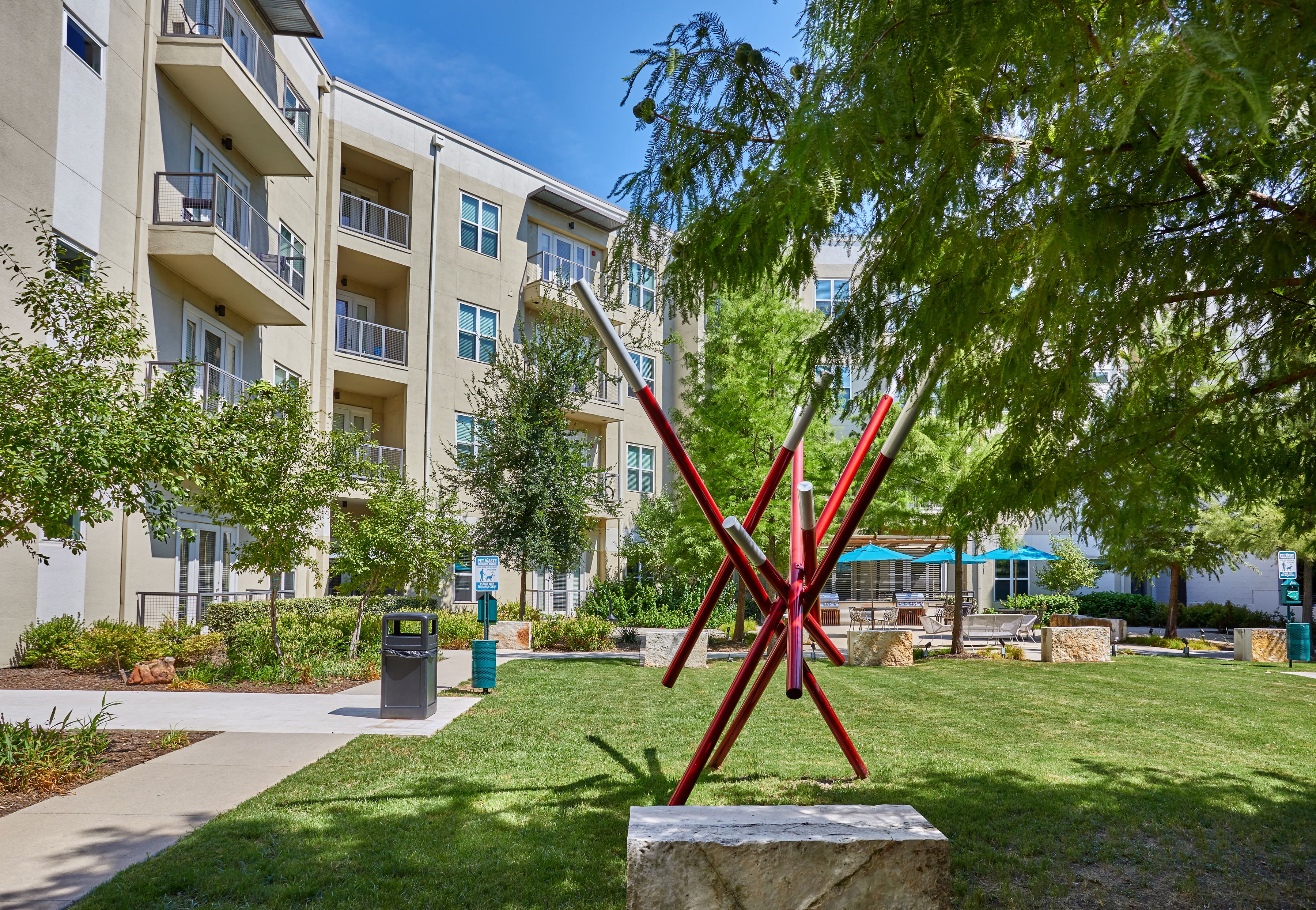 Community exterior and courtyard with a large red sculpture