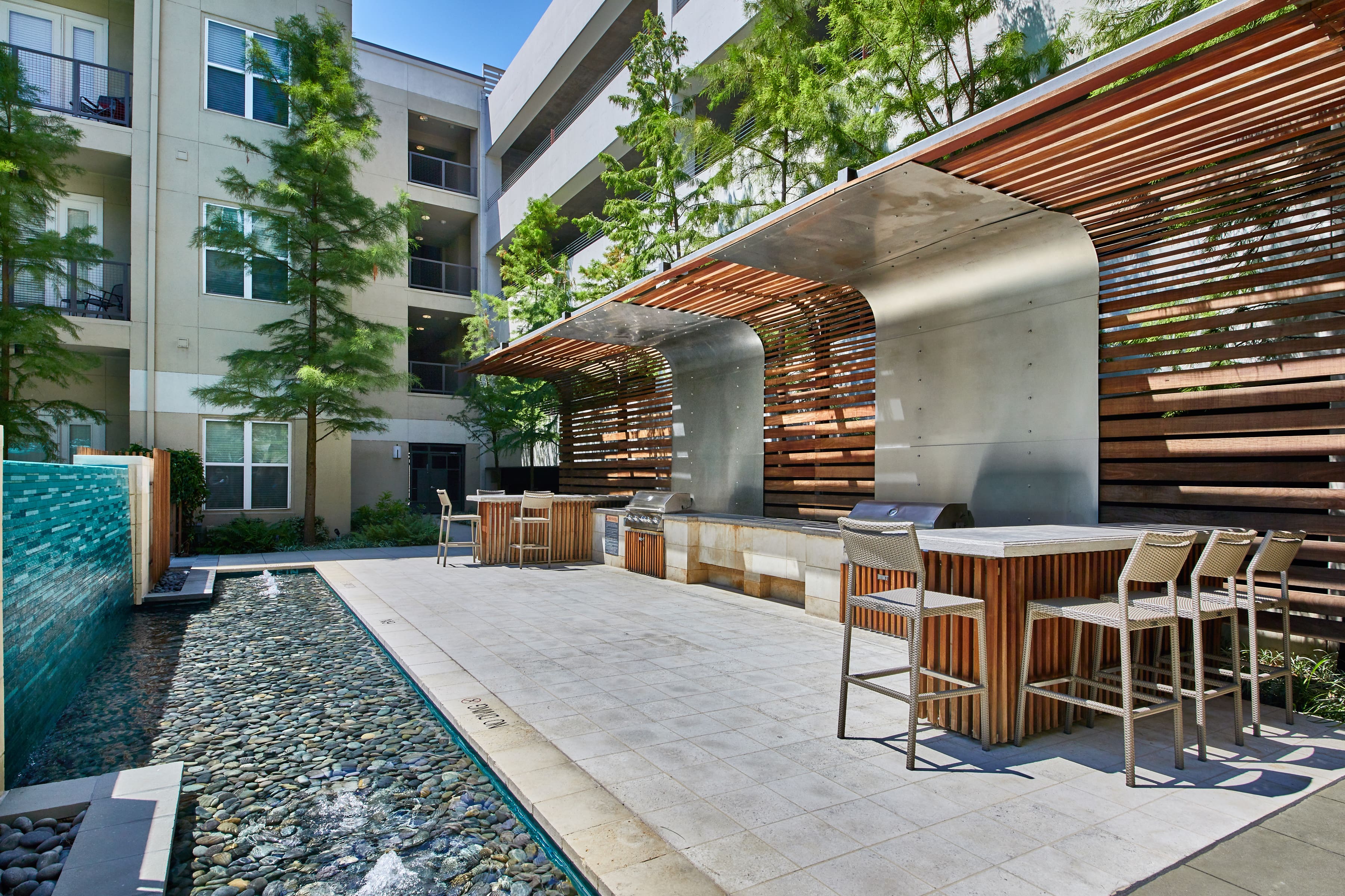 Poolside lounge area with BBQ grills and high-top seating areas