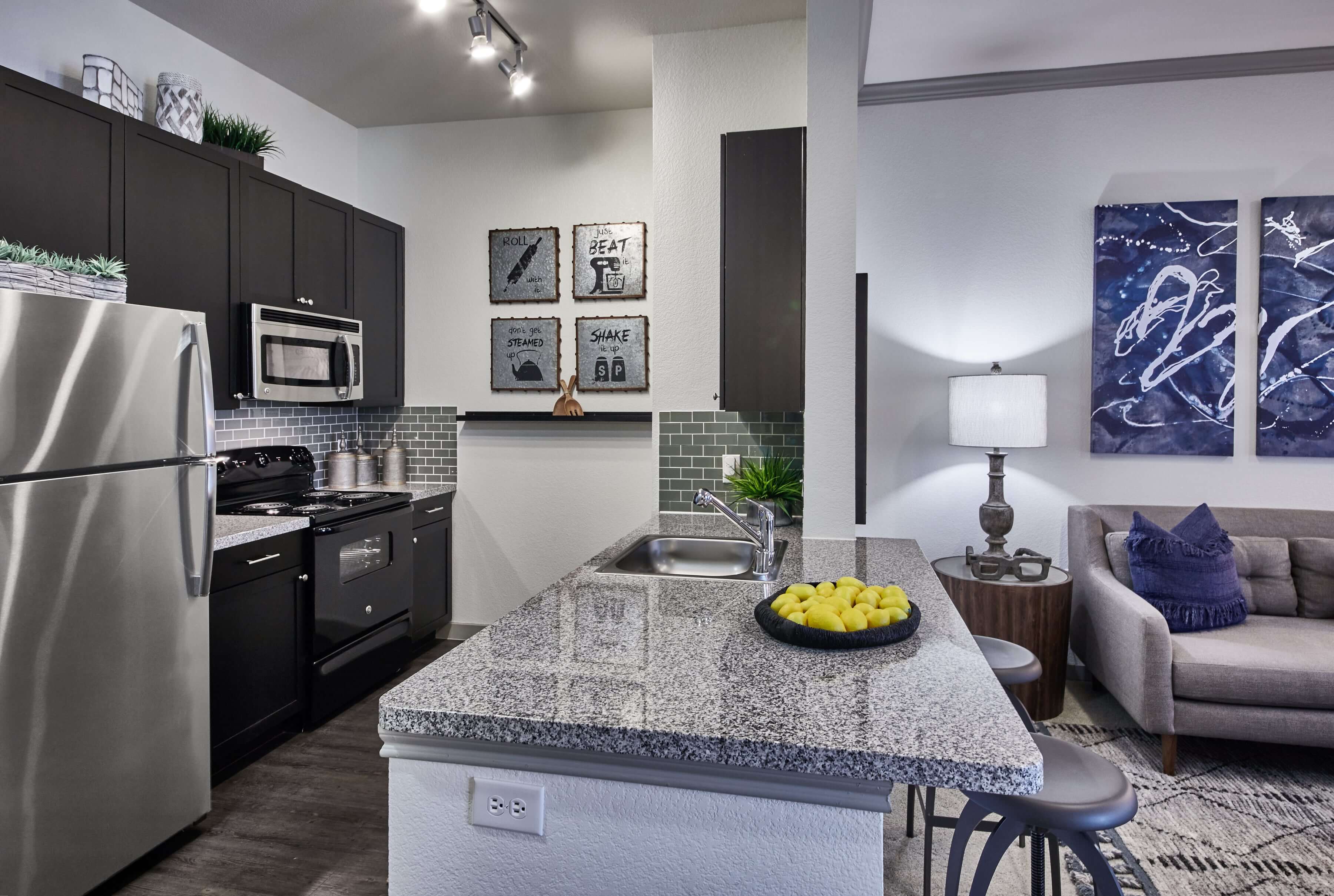 Kitchen with dark brown cabinetry, granite countertops, and a large island